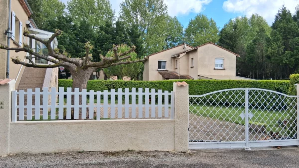 clôture en pvc blanc ajourée coupe bombée installée sur un muret