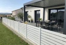 clôture en PVC blanc légèrement ajourée autour d'une terrasse en bois