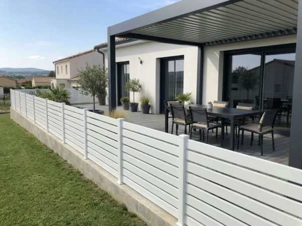 clôture en PVC blanc légèrement ajourée autour d'une terrasse en bois