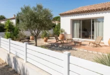 clôture ajourée blanche sur muret prés d'une terrasse ensoleillée