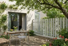 clôture à lames verticales grises posée prés d'un terrasse en bois