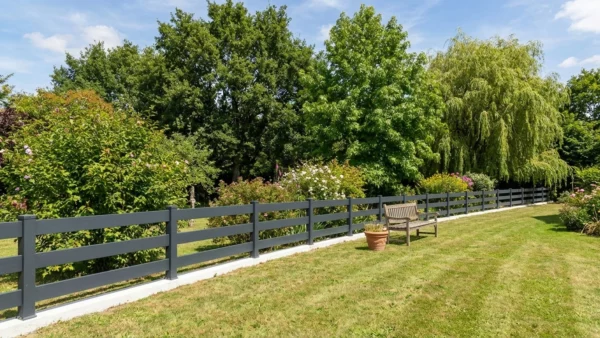 clôture ajourée tendance posée sur une longrine béton dans un jardin arboré