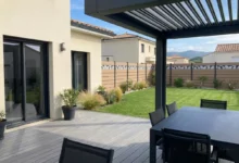 clôture composite imprimé tropical avec des inserts en aluminium installée dans un jardin prés d'une pergola bioclimatique