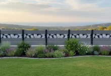 clôture composite grise posée sur un petit muret dans le jardin d'une maison avec vue