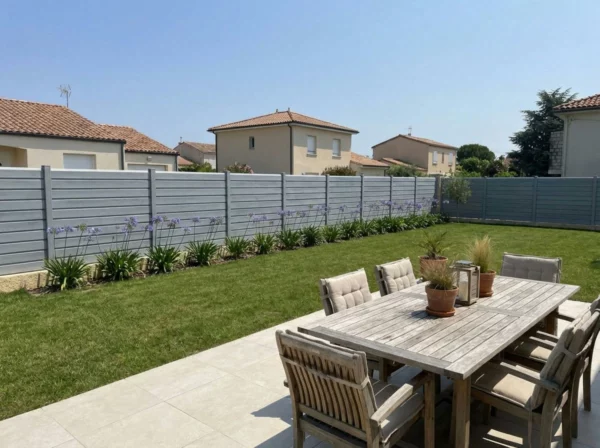 clôture PVC de couleur gris clair dans un jardin de lotissement paysagé