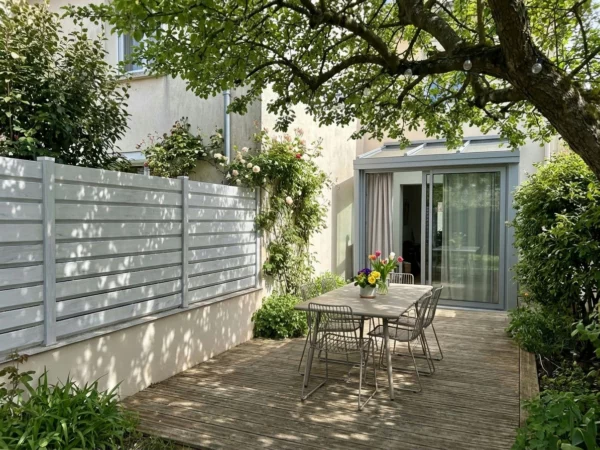 clôture de teinte gris clair posée sur un petit muret crépis mitoyen entre deux voisins