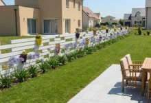clôture en pvc blanc avec des pots de fleurs intégrés à la clôture dans un jardin