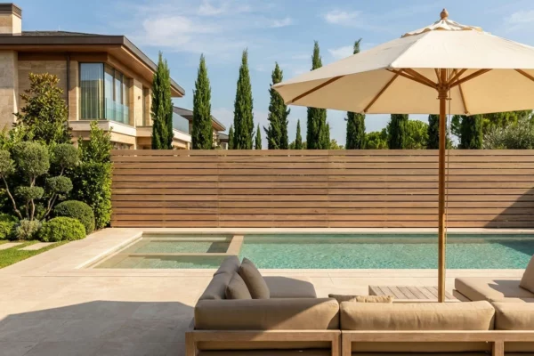 Clôture sans poteau ajourée effet bois installée prés d'une piscine dans une maison luxueuse