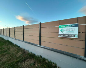 Clôture composite beige installée sur muret pour sublimer votre maison