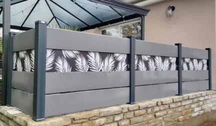 Apporter une touche d'originalité avec des impressions sur votre clôture composite gris installée sur muret en pierre