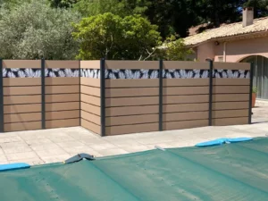 Service de pose pour une sublime clôture en composite beige avec des impressions tropicales pour apporter une touche d'originalité à votre terrasse