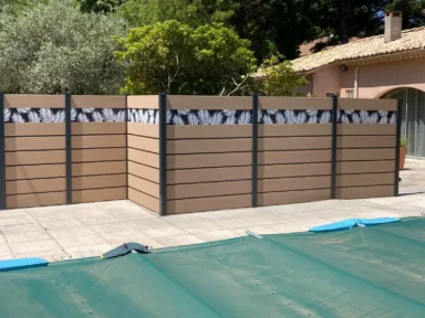 Service de pose pour une sublime clôture en composite beige avec des impressions tropicales pour apporter une touche d'originalité à votre terrasse