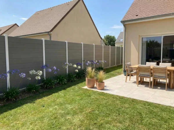 Clôture en composite à lames horizontales occultantes installée dans un jardin de maisons de lotissement