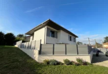 clôture composite grise autour d'une maison dans un lotissement