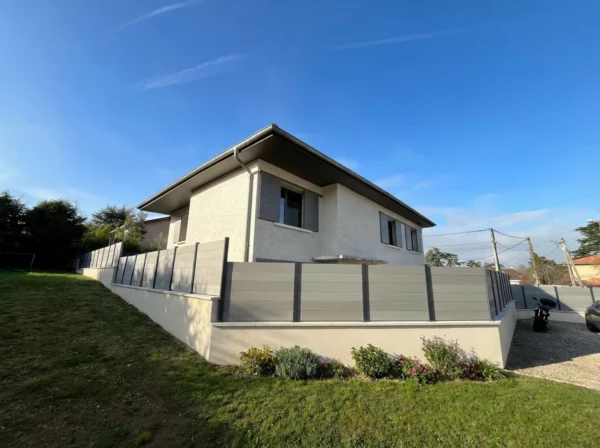 clôture composite grise autour d'une maison dans un lotissement
