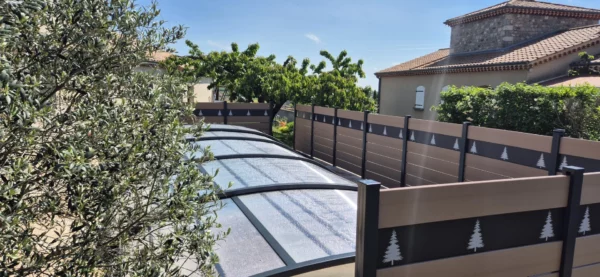 Clôture occultante autour d'une piscine personnalisée avec des motifs sapins