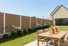 Clôture occultante effet bois installée sur un muret dans un jardin arboré