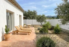 clôture blanche installée sur un muret en parpaing dans un jardin d'ambiance méditerranéenne