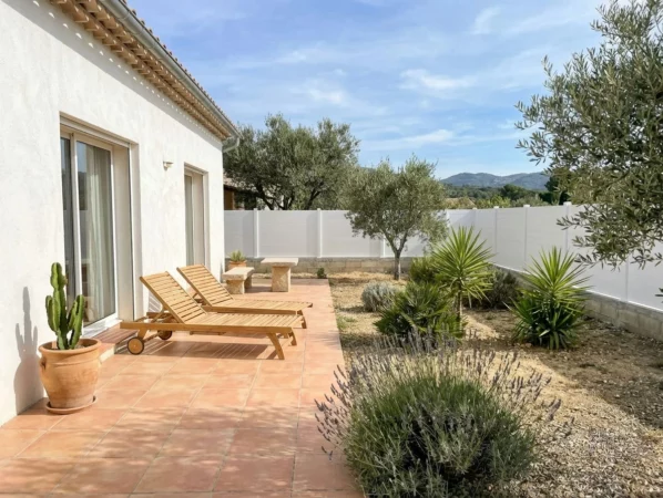 clôture blanche installée sur un muret en parpaing dans un jardin d'ambiance méditerranéenne