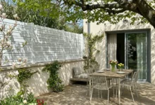 clôture blanche installée sur un muret sur couvertine en béton dans un jardin bucolique