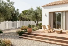 clôture ajourée barreaudée blanche posée sur un muret