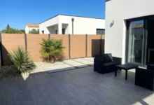 clôture beige en composite posée en pleine terre dans un jardin