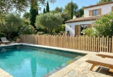 clôture à lames verticales ajourées effet bois autour d'une piscine