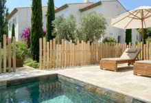 clôture effet bois installée sur une terrasse en carrelage travertin autour d'une piscine