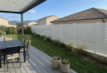 clôture PVC ajourée blanche dans le jardin d'une maison de lotissement récente