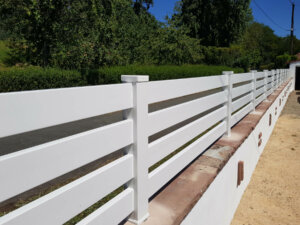 Clôture en pvc blanc ajouré installée avec un espacement de 50 mm entre chaque lames horizontales