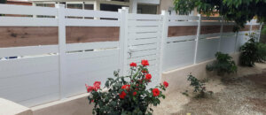 Clôture en pvc blanc ajourée originale installée avec des impressions imitation bois
