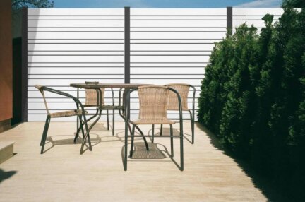 Clôture en pvc blanc ajourée instaléeavec des poteaux aluminium gris anthracite alternant des lames horizontales de différentes largeurs : de 100 et 50 mm