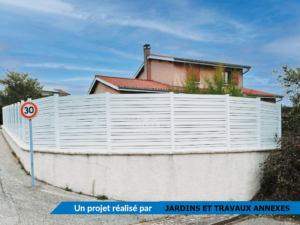 Clôture en pvc blanc ajourée instaléeavec des poteaux aluminium blanc alternant des lames horizontales de différentes largeurs : de 100 et 50 mm
