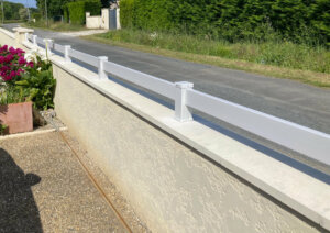 Clôture en pvc gris ajouré installée sur muret avec une seule lame