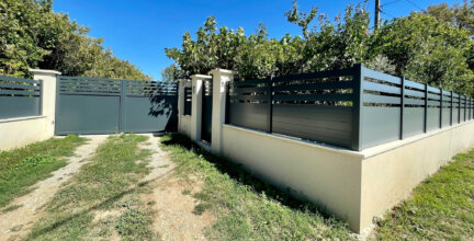 Clôture en pvc plaxé gris anthracite ajouré installée sur muret avec un joli portail assorti
