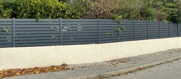 Clôture en pvc plaxé gris anthracite ajouré installée sur muret