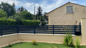 Aménager sa clôture en pvc plaxé gris anthracite ajouré sur muret avec le portail assorti