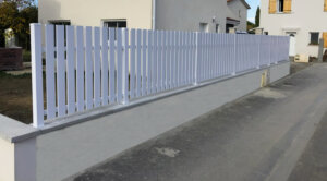 Clôture en pvc blanc ajourée installée sur muret