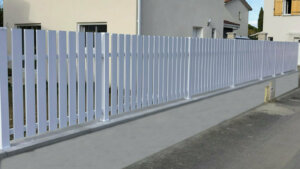 Clôture en pvc blanc ajourée installée sur muret