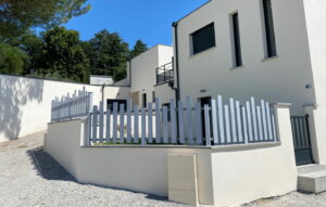 Clôture en pvc gris ajourée installée avec des lames irrégulières idéal pour maison de lotissement