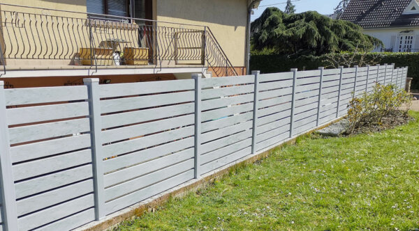 Clôture en pvc gris ajouré installée avec un espacement de 10 mm entre chaque lames horizontales