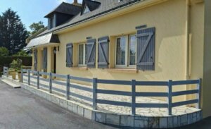 Clôture en pvc gris ajourée installée sur une belle terrasse en pierre