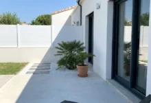 clôture brise vue blanche installée sur un muret crépis entre deux maisons