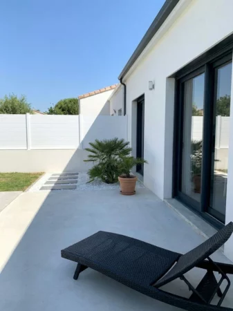 clôture brise vue blanche installée sur un muret crépis entre deux maisons
