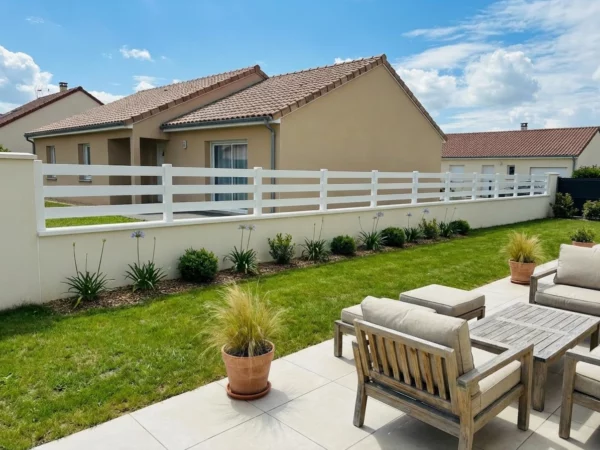 clôture en PVC blanche posée dans le jardin d'une maison contemporaine