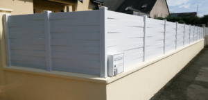 Clôture en pvc blanc brise-vue aux lames entrelacées avec une intégration parfaite d'une boîte aux lettres