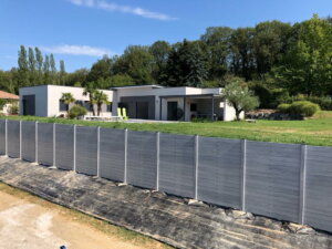 Clôture en pvc gris brise-vue installée sur muret avec une originalité particulière pour un rendu uni