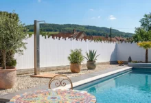 clôture brise vue en pvc blanc coupe irrégulière installée autour d'une piscine