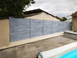 Clôture en pvc gris brise-vue installée en bord de piscine
