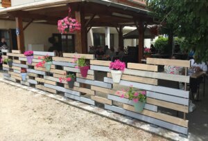 Clôture en pvc multicolore brise-vue avec l'intégration de pots de fleurs aux différentes couleurs installée en bord de terrasse